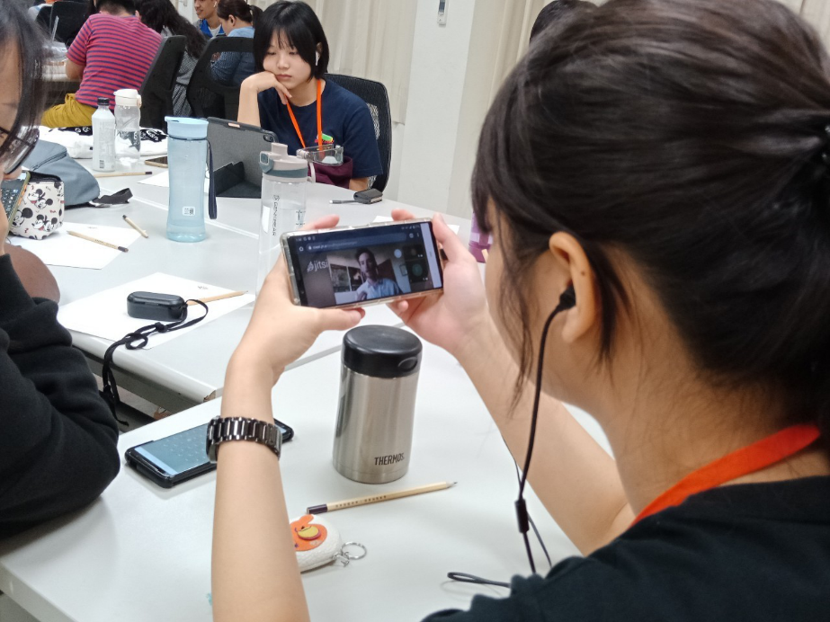 志工團透過手機視訊與SVA 會長互動。 圖:高雄市政府/提供 志工團透過手機視訊與SVA 會長互動。 圖:高雄市政府/提供