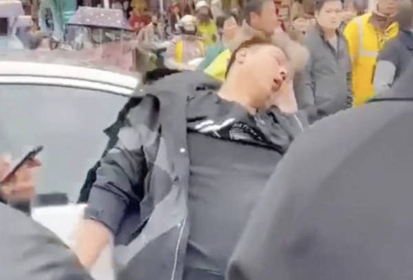 賓士車主被外送大軍打到癱軟趴在車上無力反抗。 圖:翻攝微博 賓士車主被外送大軍打到癱軟趴在車上無力反抗。 圖:翻攝微博