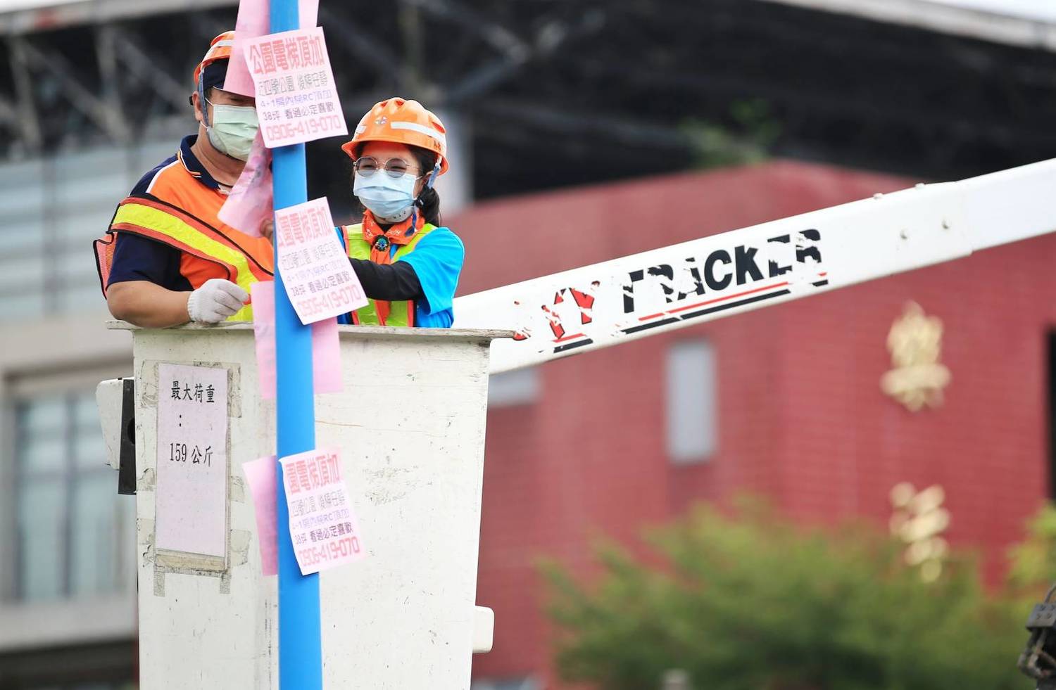 環保小局長搭上高空作業車體驗撕除小廣告的不易與辛苦。 圖:新北市環保局提供 環保小局長搭上高空作業車體驗撕除小廣告的不易與辛苦。 圖:新北市環保局提供
