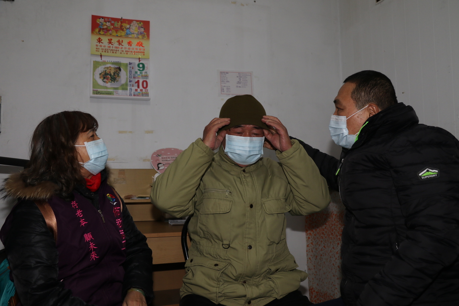 侯友宜特別帶了毛帽幫阿榮戴上 左為佈老志工張麗淑。 圖:新北市社會局提供 侯友宜特別帶了毛帽幫阿榮戴上 左為佈老志工張麗淑。 圖:新北市社會局提供