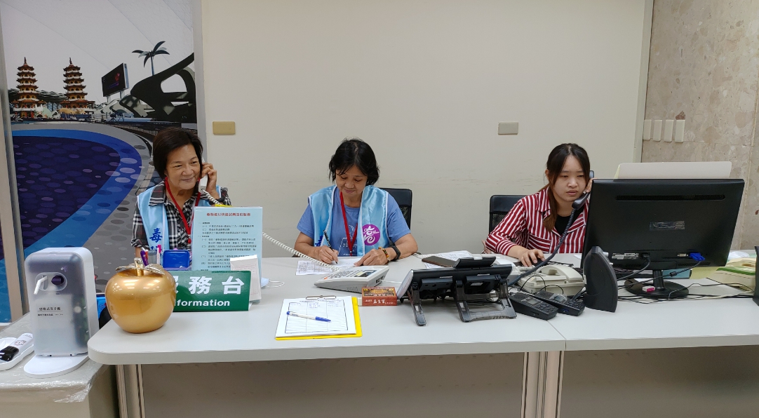 阿琴志工(中)在毒防局服務台值勤,協助記錄民眾諮詢服務內容。 圖 : 高雄市政府毒品防制局/提供 阿琴志工(中)在毒防局服務台值勤,協助記錄民眾諮詢服務內容。 圖 : 高雄市政府毒品防制局/提供