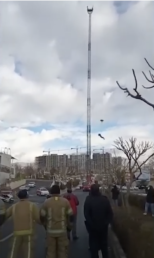博佐奇從距地面58公尺的雲梯車頂端進行跳傘活動,快達地面跳傘卻未順利展開,直墜而下當場死亡。 圖:翻攝自Artemis-TV Plus Youtube頻道 博佐奇從距地面58公尺的雲梯車頂端進行跳傘活動,快達地面跳傘卻未順利展開,直墜而下當場死亡。 圖:翻攝自Artemis-TV Plus Youtube頻道