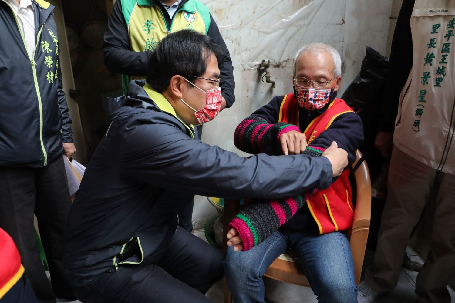 黃偉哲關心阿公保暖問題,親手為阿公穿戴防寒衣物。 圖:台南市政府提供 黃偉哲關心阿公保暖問題,親手為阿公穿戴防寒衣物。 圖:台南市政府提供