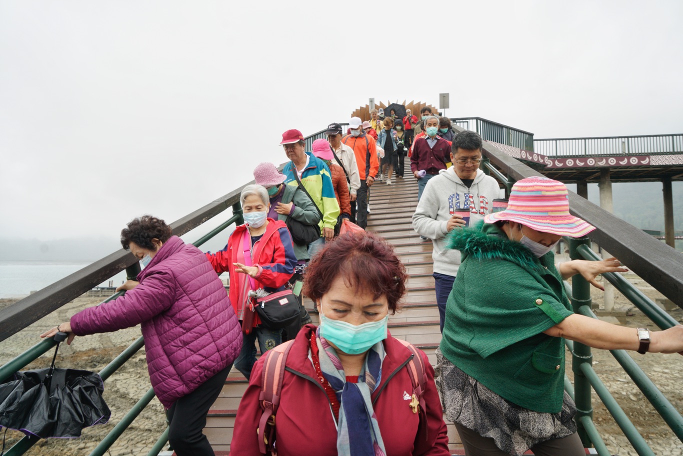 到日月潭觀光的遊客雙手抓著引橋的欄杆一步一步走去登船。 圖:張良一/攝 到日月潭觀光的遊客雙手抓著引橋的欄杆一步一步走去登船。 圖:張良一/攝