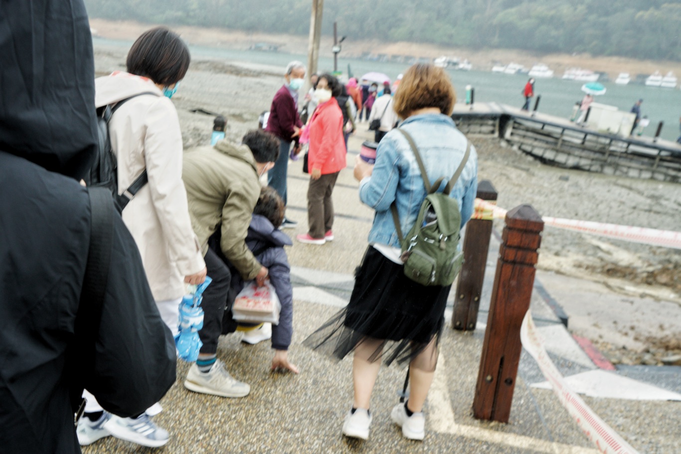 一位遊客往伊達邵碼頭引橋走下去時,由於坡度大加上天雨路滑,走著走著滑倒了,引起同伴一陣尖叫。 圖:張良一/攝 一位遊客往伊達邵碼頭引橋走下去時,由於坡度大加上天雨路滑,走著走著滑倒了,引起同伴一陣尖叫。 圖:張良一/攝