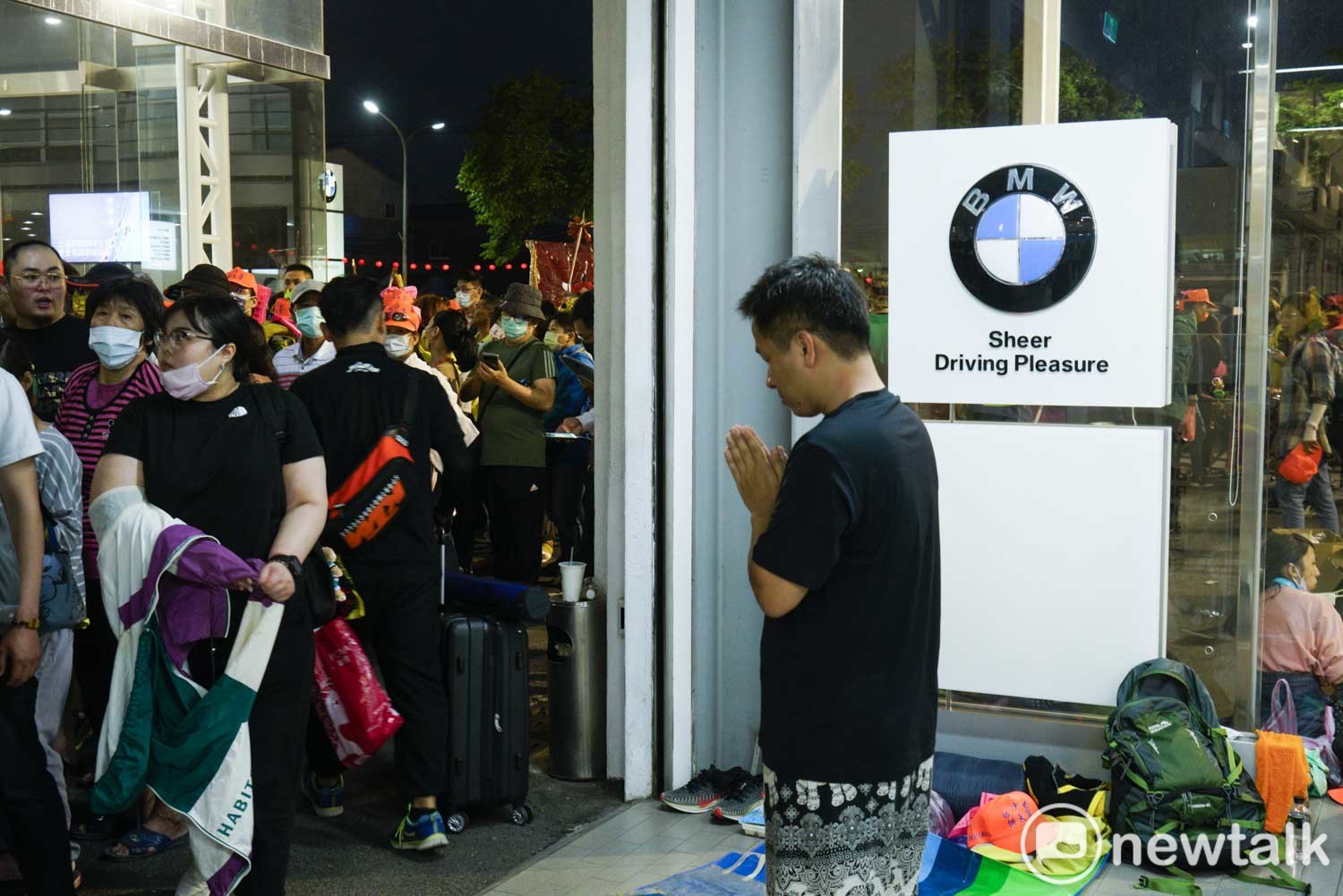 一位進香客在銷售BMW汽車的彰化昌一汽車維修中心內,雙手合十向白沙屯媽祖祈福。 圖:張良一/攝 一位進香客在銷售BMW汽車的彰化昌一汽車維修中心內,雙手合十向白沙屯媽祖祈福。 圖:張良一/攝