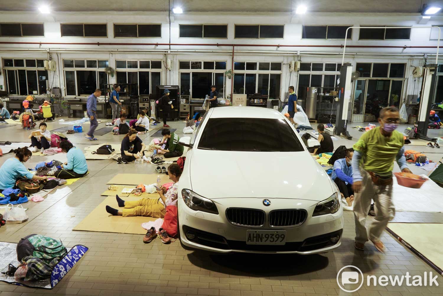 數百位進香客在BMW花壇維修中心內打地鋪休息。 圖:張良一/攝 數百位進香客在BMW花壇維修中心內打地鋪休息。 圖:張良一/攝