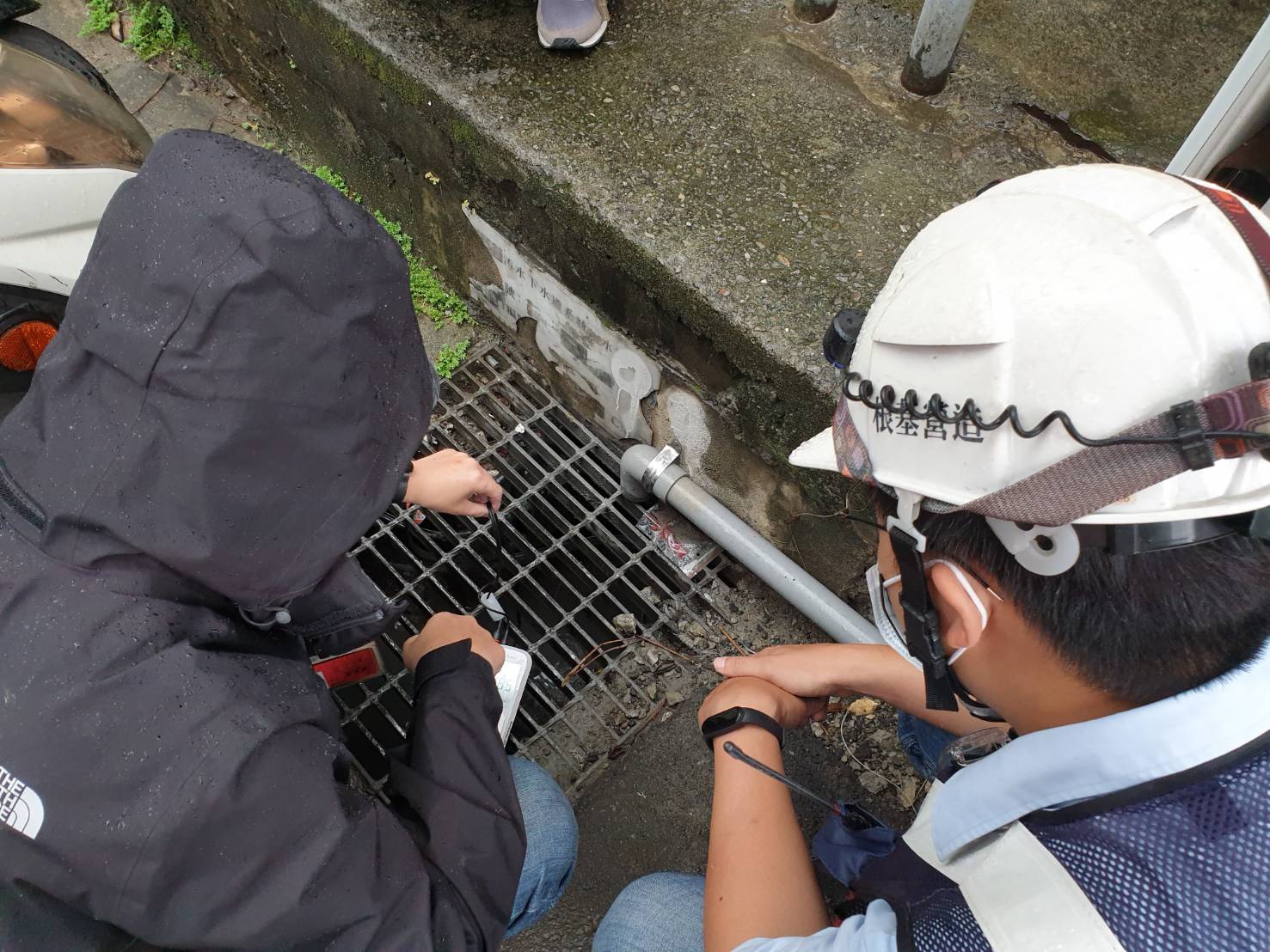 與現場營建工地作業人員共同查核逕流廢水放流口處水溝狀況 圖:新北市政府環保局提供 與現場營建工地作業人員共同查核逕流廢水放流口處水溝狀況 圖:新北市政府環保局提供