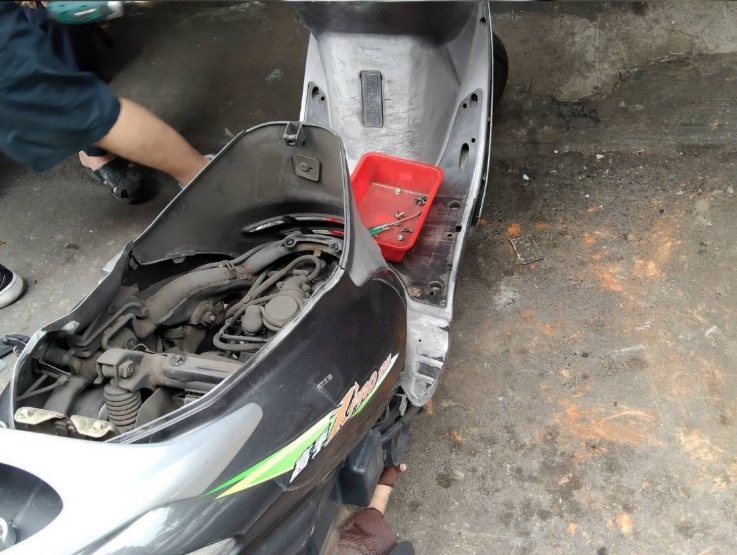 機車行協助拆下車殼,尋找蛇的蹤影。 圖:新北市動保處提供 機車行協助拆下車殼,尋找蛇的蹤影。 圖:新北市動保處提供