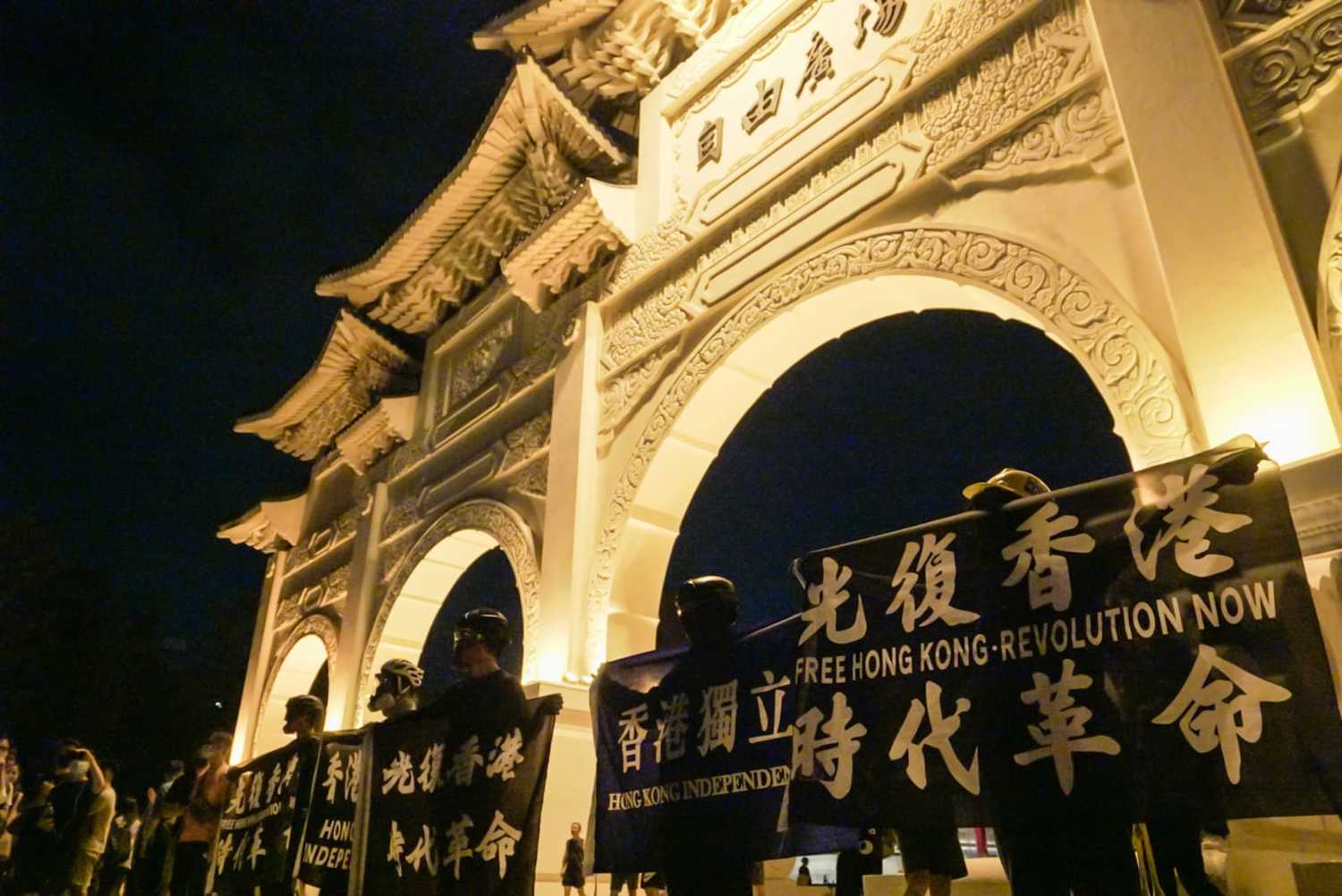 陳樂晞《不具名:自由的代價》:劇照一群在台香港人在自由廣場前舉「香港獨立」布條。 圖:新北市新聞局提供 陳樂晞《不具名:自由的代價》:劇照一群在台香港人在自由廣場前舉「香港獨立」布條。 圖:新北市新聞局提供