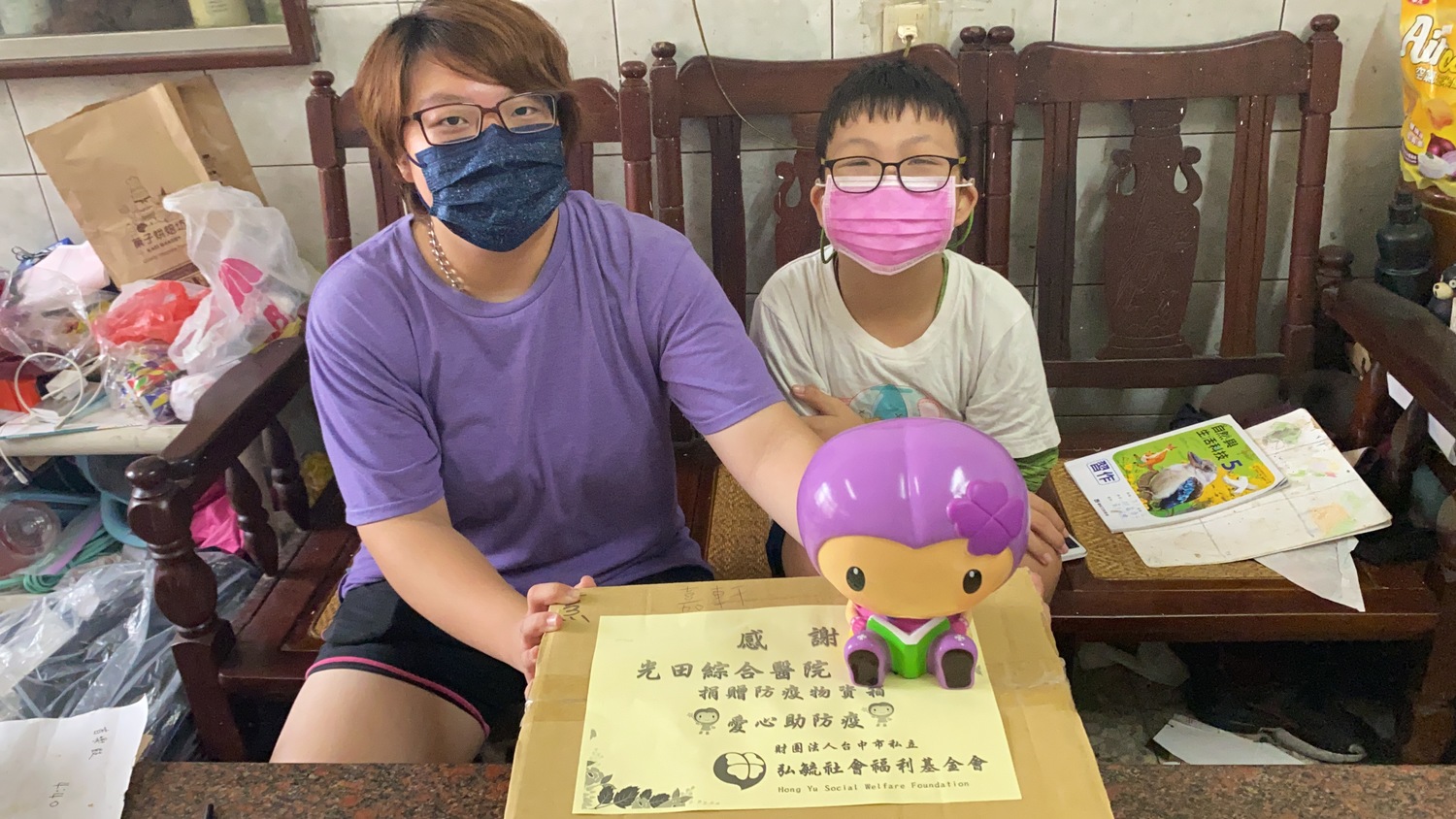 受疫情影響生活的嘉軒(右)與姐姐收下關懷物資,欣慰表示能減輕經濟負擔。 光田綜合醫院/提供 受疫情影響生活的嘉軒(右)與姐姐收下關懷物資,欣慰表示能減輕經濟負擔。 光田綜合醫院/提供