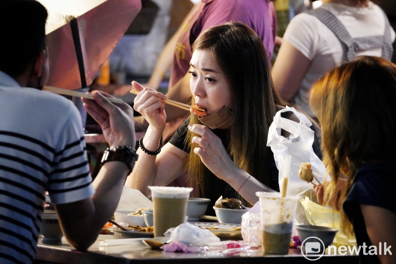 逛夜市的民眾大快朵頤。 圖:張良一/攝 逛夜市的民眾大快朵頤。 圖:張良一/攝