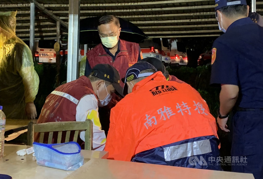 雙北地區多位家長與學生16日到新北市虎豹潭一帶參加自然體驗營,午後遇大雨折返途中有多人落水,晚間仍有6人失聯,現場全力搜救中,新北市長侯友宜(坐者左)晚間趕赴現場了解狀況。 圖:中央社 雙北地區多位家長與學生16日到新北市虎豹潭一帶參加自然體驗營,午後遇大雨折返途中有多人落水,晚間仍有6人失聯,現場全力搜救中,新北市長侯友宜(坐者左)晚間趕赴現場了解狀況。 圖:中央社