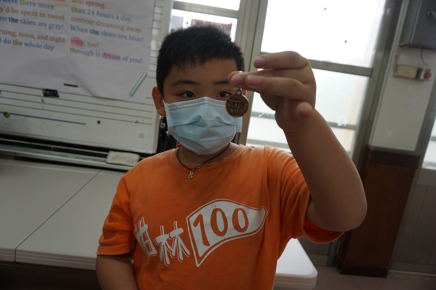 小學生手上拿的是今年度狂犬病疫苗注射證明金色頸牌。 圖:新北市動保處提供 小學生手上拿的是今年度狂犬病疫苗注射證明金色頸牌。 圖:新北市動保處提供
