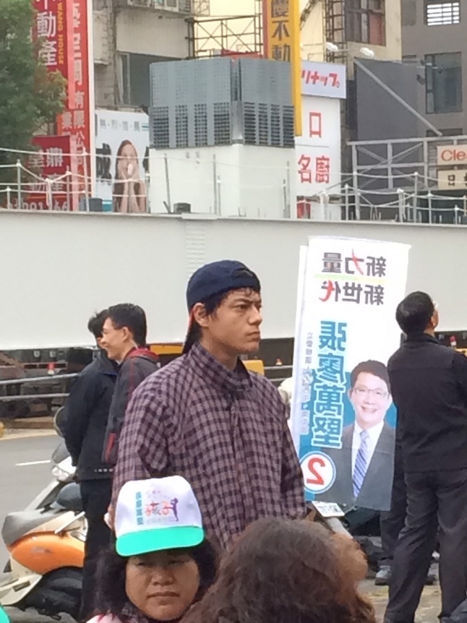 長得極像蔣友青的男子,反戴球帽,在綠營的造勢場子聽了將近1個半小時的演講。 圖:林姓民眾提供 長得極像蔣友青的男子,反戴球帽,在綠營的造勢場子聽了將近1個半小時的演講。 圖:林姓民眾提供