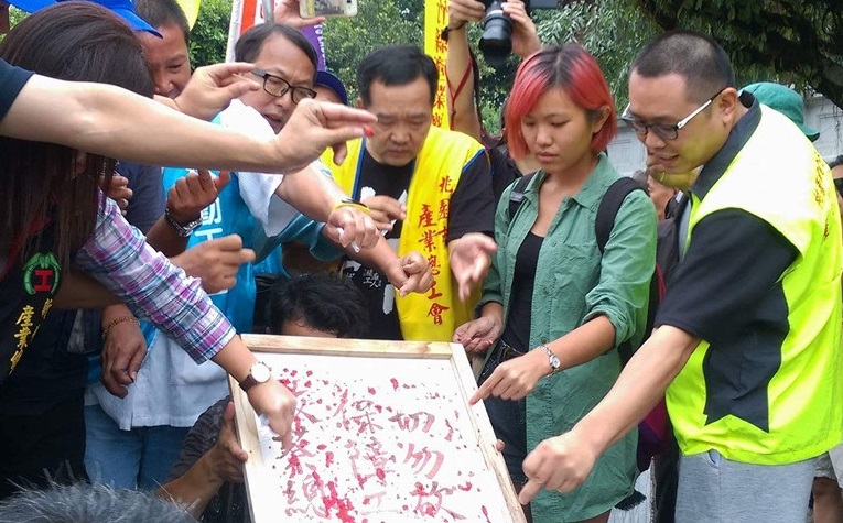 勞團28日下午刺破中指寫出「保障工人權益,切勿砍7天假」寫書,送進總統府陳情。 圖:翻攝臉書 勞團28日下午刺破中指寫出「保障工人權益,切勿砍7天假」寫書,送進總統府陳情。 圖:翻攝臉書