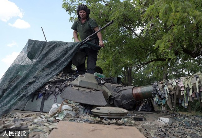 頓巴斯地區,烏克蘭軍人蓋住一輛坦克作為掩護。 圖:翻攝自視覺中國 頓巴斯地區,烏克蘭軍人蓋住一輛坦克作為掩護。 圖:翻攝自視覺中國