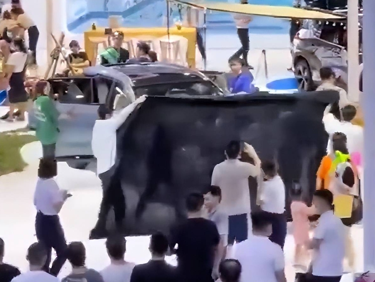 重慶汽車展,車商用黑布來遮擋抗議的維權車主。 圖 : 翻攝自微博 重慶汽車展,車商用黑布來遮擋抗議的維權車主。 圖 : 翻攝自微博