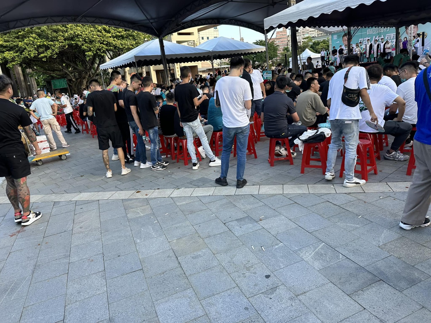 民眾黨三重造勢場合黑衣人群起抽菸嚼檳榔,現場地板上滿地的菸蒂和檳榔汁 圖:四叉貓臉書 民眾黨三重造勢場合黑衣人群起抽菸嚼檳榔,現場地板上滿地的菸蒂和檳榔汁 圖:四叉貓臉書