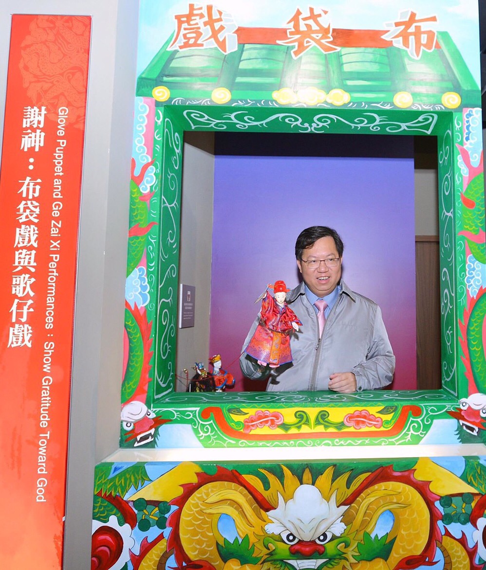 桃園土地公文化館內,為呈現傳統廟會文化特色,還特地設置了歌仔戲台和布袋戲棚,當然也有傳統布袋戲的布偶,桃園市長鄭文燦,每次視察時,都不忘拿起布偶,把玩一下,重溫回味童年的滋味。 圖:翻攝自桃園市文化基金會官網 桃園土地公文化館內,為呈現傳統廟會文化特色,還特地設置了歌仔戲台和布袋戲棚,當然也有傳統布袋戲的布偶,桃園市長鄭文燦,每次視察時,都不忘拿起布偶,把玩一下,重溫回味童年的滋味。 圖:翻攝自桃園市文化基金會官網