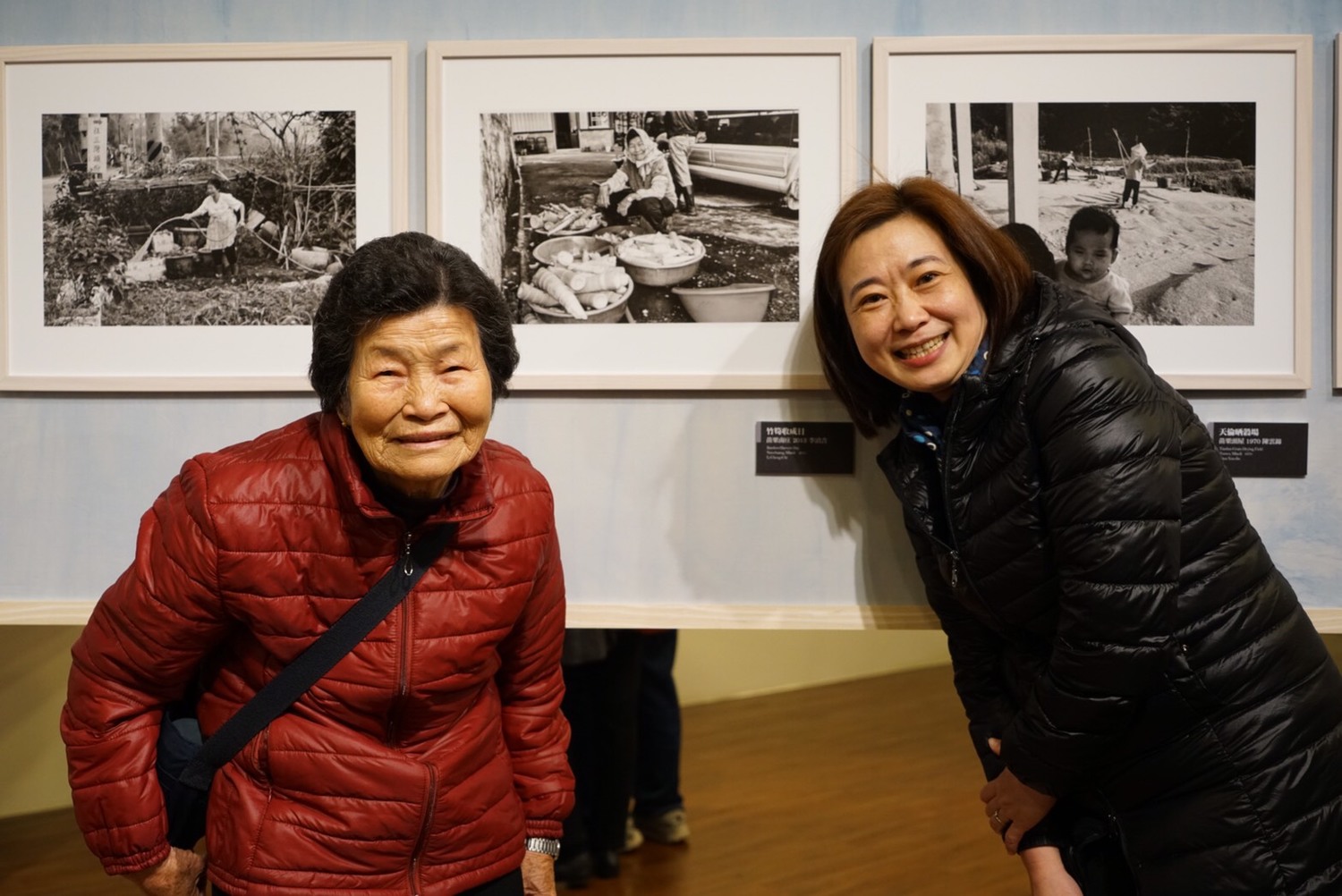 旅程.印象台三線攝影展的策展人劉慧貞(右1)與背後照片的影中人本尊彭金妹,今年已高齢85歲的彭金妹,看著年輕時整理山城特產桂竹筍的影像,笑的闔不攏嘴。 圖:台灣水/黃裕順提供 旅程.印象台三線攝影展的策展人劉慧貞(右1)與背後照片的影中人本尊彭金妹,今年已高齢85歲的彭金妹,看著年輕時整理山城特產桂竹筍的影像,笑的闔不攏嘴。 圖:台灣水/黃裕順提供