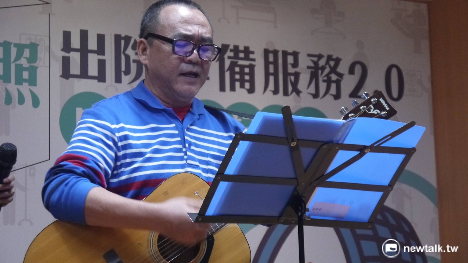 受邀參加記者會的個案張先生正在台上表演吉他。 圖:鍾孟軒/攝 受邀參加記者會的個案張先生正在台上表演吉他。 圖:鍾孟軒/攝