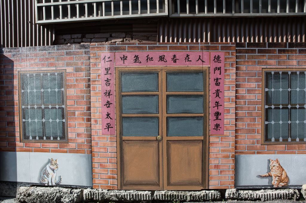 美仁里彩繪巷內的壁畫,記錄了居民往昔的生活。壁畫上的母貓,在對公貓說些什麼呢? 圖:翻攝自台中觀光旅遊網 美仁里彩繪巷內的壁畫,記錄了居民往昔的生活。壁畫上的母貓,在對公貓說些什麼呢? 圖:翻攝自台中觀光旅遊網