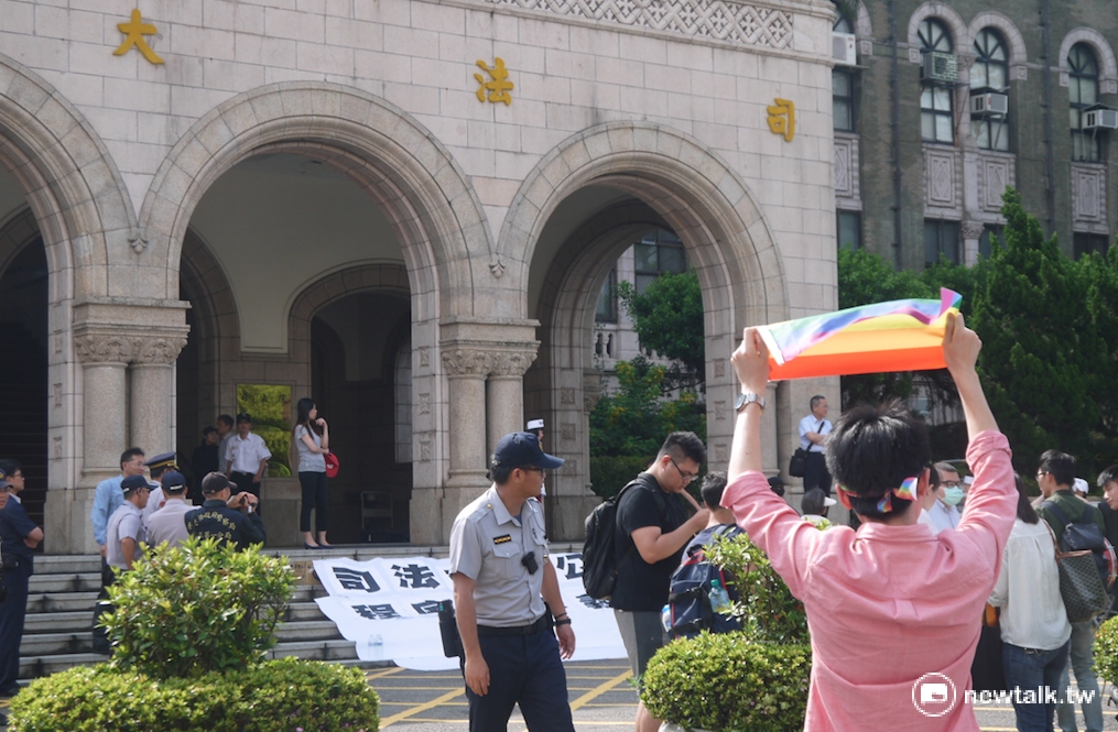 臺灣大學法研所學生獨自一人前往司法院高舉彩虹旗支持同性婚姻法案。 臺灣大學法研所學生獨自一人前往司法院高舉彩虹旗支持同性婚姻法案。