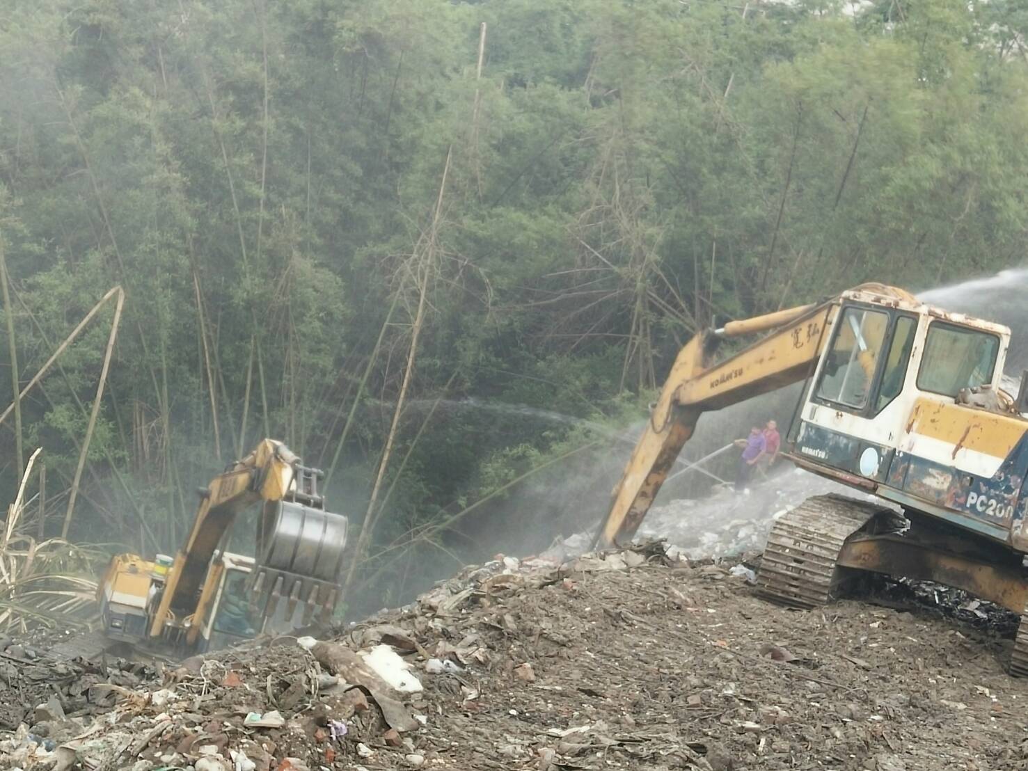 高雄市旗山區旗文路被棄置廢棄物數度悶燒冒煙,高雄市環保局出動灑水車6部,怪手1部,持續以怪手開挖及灑水,目前已暫時滅。 圖:高雄市政府提供 高雄市旗山區旗文路被棄置廢棄物數度悶燒冒煙,高雄市環保局出動灑水車6部,怪手1部,持續以怪手開挖及灑水,目前已暫時滅。 圖:高雄市政府提供