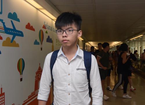 香港社運人士黃之鋒11日上午來台,他被問到此行是否參加林飛帆的婚禮,僅點頭致意,沒有接受任何採訪。 圖:中央社 香港社運人士黃之鋒11日上午來台,他被問到此行是否參加林飛帆的婚禮,僅點頭致意,沒有接受任何採訪。 圖:中央社