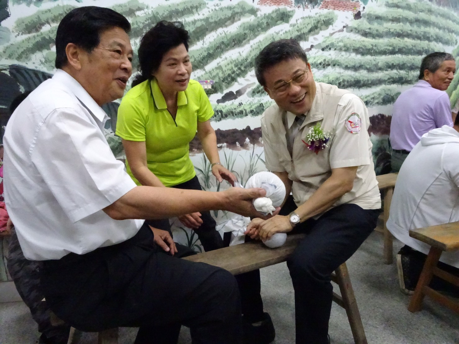 參山處處長吳主治坐在長板凳上體驗早期茶農以長巾揉茶。 參山處處長吳主治坐在長板凳上體驗早期茶農以長巾揉茶。