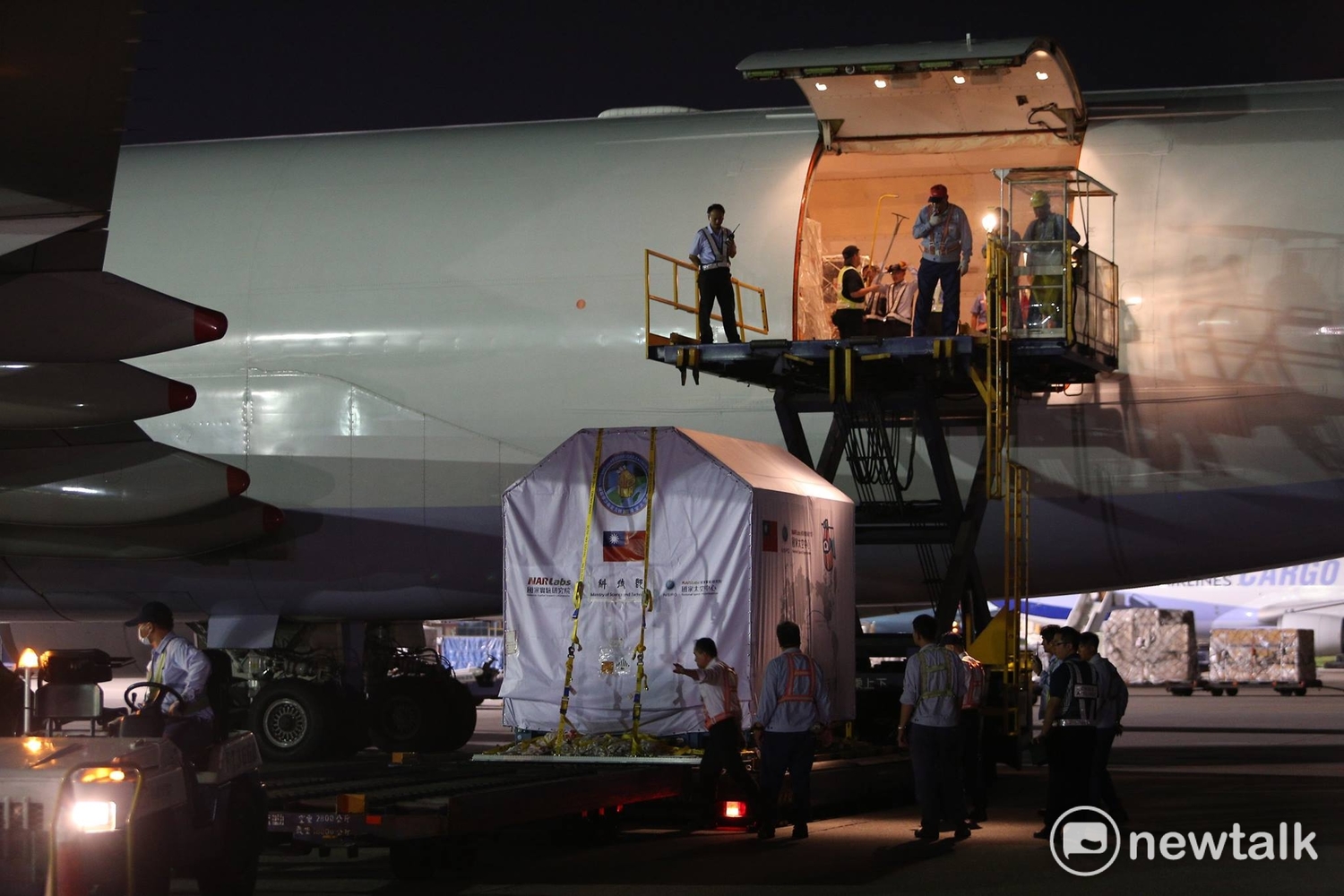 福衛五號從華儲倉庫運抵停機坪在波音747-400貨機前,接駁車運抵機門下,準備進行升載進貨機內。 圖:陳奕/攝 福衛五號從華儲倉庫運抵停機坪在波音747-400貨機前,接駁車運抵機門下,準備進行升載進貨機內。 圖:陳奕/攝