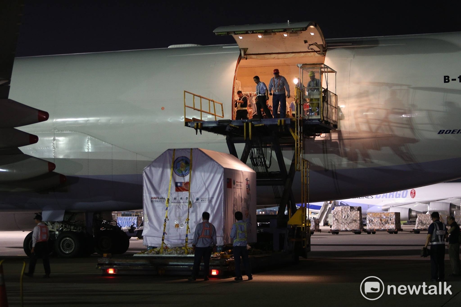 福衛五號從華儲倉庫運抵停機坪在波音747-400貨機前,接駁車運抵機門下,準備進行升載進貨機內。 圖:陳奕/攝 福衛五號從華儲倉庫運抵停機坪在波音747-400貨機前,接駁車運抵機門下,準備進行升載進貨機內。 圖:陳奕/攝