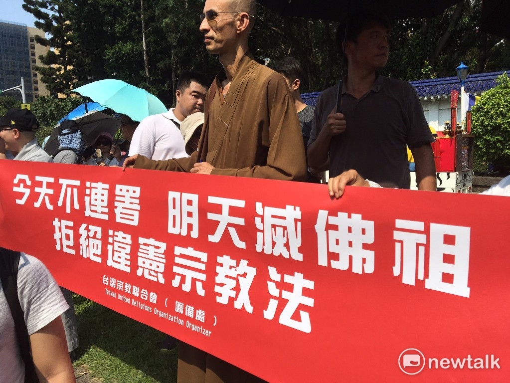 有人舉出「今天不連署,明天滅佛祖」的標語,反對違憲宗教法。 圖:鍾孟軒/攝 有人舉出「今天不連署,明天滅佛祖」的標語,反對違憲宗教法。 圖:鍾孟軒/攝