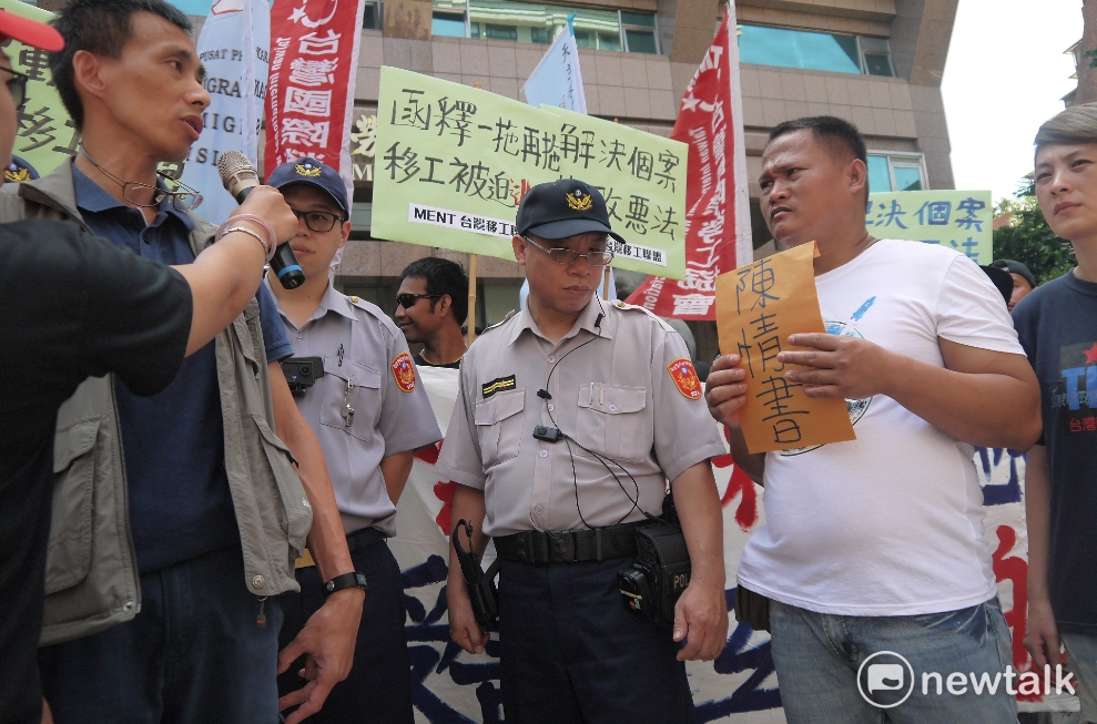 勞動部官員與漁工J先生。J先生正要把陳情書交給勞動部官員,希望勞動部能盡快解決撤銷逃跑移工的註記,否則一年多來完全沒收入也無法工作。 圖:鍾孟軒/攝 勞動部官員與漁工J先生。J先生正要把陳情書交給勞動部官員,希望勞動部能盡快解決撤銷逃跑移工的註記,否則一年多來完全沒收入也無法工作。 圖:鍾孟軒/攝