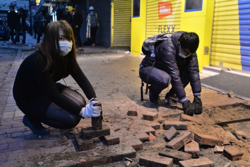 香港旺角騷動事件中,有37人被控「暴動罪」,當年17歲的李倩怡也是被告之一。圖為參與騷動者,在街上挖掘磚頭丟擲警方。 圖 : 翻攝自香港高登.com 香港旺角騷動事件中,有37人被控「暴動罪」,當年17歲的李倩怡也是被告之一。圖為參與騷動者,在街上挖掘磚頭丟擲警方。 圖 : 翻攝自香港高登.com