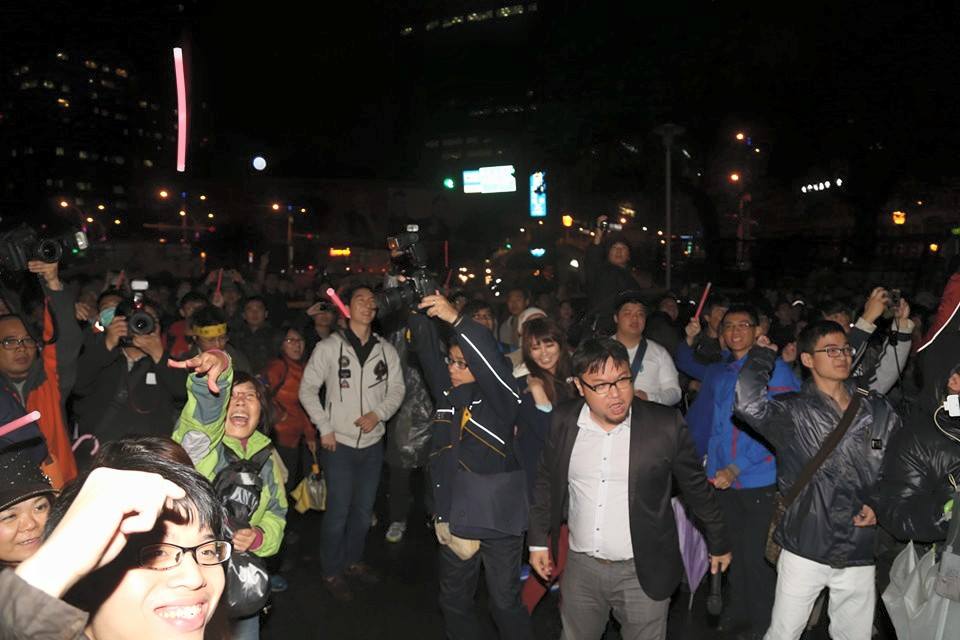 在警方第二次舉牌前,林于倫帶著所有民眾高呼一年前喊的「退回服貿,捍衛民主」,並把手中的紅色螢光棒往行政院內丟擲。圖:林雨佑/攝 在警方第二次舉牌前,林于倫帶著所有民眾高呼一年前喊的「退回服貿,捍衛民主」,並把手中的紅色螢光棒往行政院內丟擲。圖:林雨佑/攝