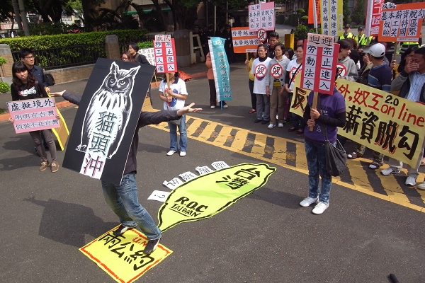外勞團體高喊「本勞外勞,同工同酬」、「外勞越便宜,本勞越悲哀」等口號,並在行政院前演出行動劇,形容「貓頭冲」的政策是讓外勞人在台灣,卻要假裝自己不在台灣,進而領取低於基本工資的薪水。圖片:楊宗興/攝 外勞團體高喊「本勞外勞,同工同酬」、「外勞越便宜,本勞越悲哀」等口號,並在行政院前演出行動劇,形容「貓頭冲」的政策是讓外勞人在台灣,卻要假裝自己不在台灣,進而領取低於基本工資的薪水。圖片:楊宗興/攝