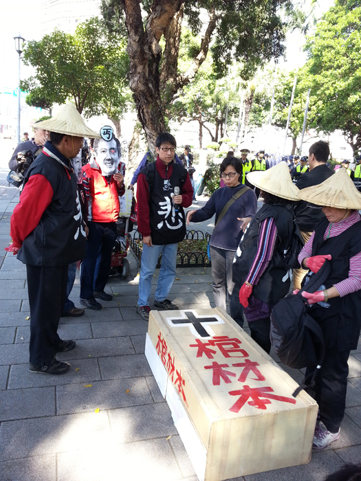 全國關廠工人連線今日於行政院門外以行動劇來表達對政府砍棺材本的不滿。圖:陳沛佑/攝 全國關廠工人連線今日於行政院門外以行動劇來表達對政府砍棺材本的不滿。圖:陳沛佑/攝