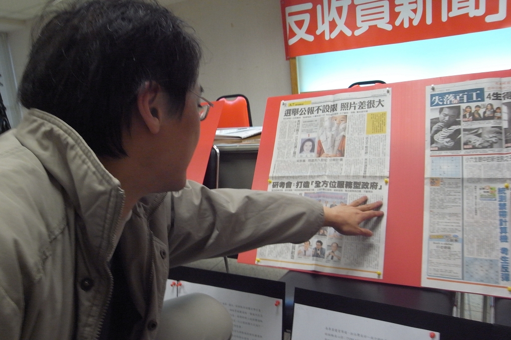 記協會長楊偉中指著報紙版面上的新聞,表示很多政府都會花錢購買新聞。圖片來源:楊宗興/攝 記協會長楊偉中指著報紙版面上的新聞,表示很多政府都會花錢購買新聞。圖片來源:楊宗興/攝
