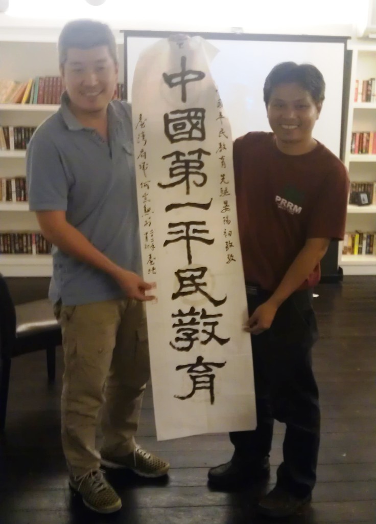中國沙龍發起人何宗勳與邱建生合影,並贈上由他書寫的「中國第一平民教育」書法給邱建生。圖片來源:莊豐嘉攝影 中國沙龍發起人何宗勳與邱建生合影,並贈上由他書寫的「中國第一平民教育」書法給邱建生。圖片來源:莊豐嘉攝影