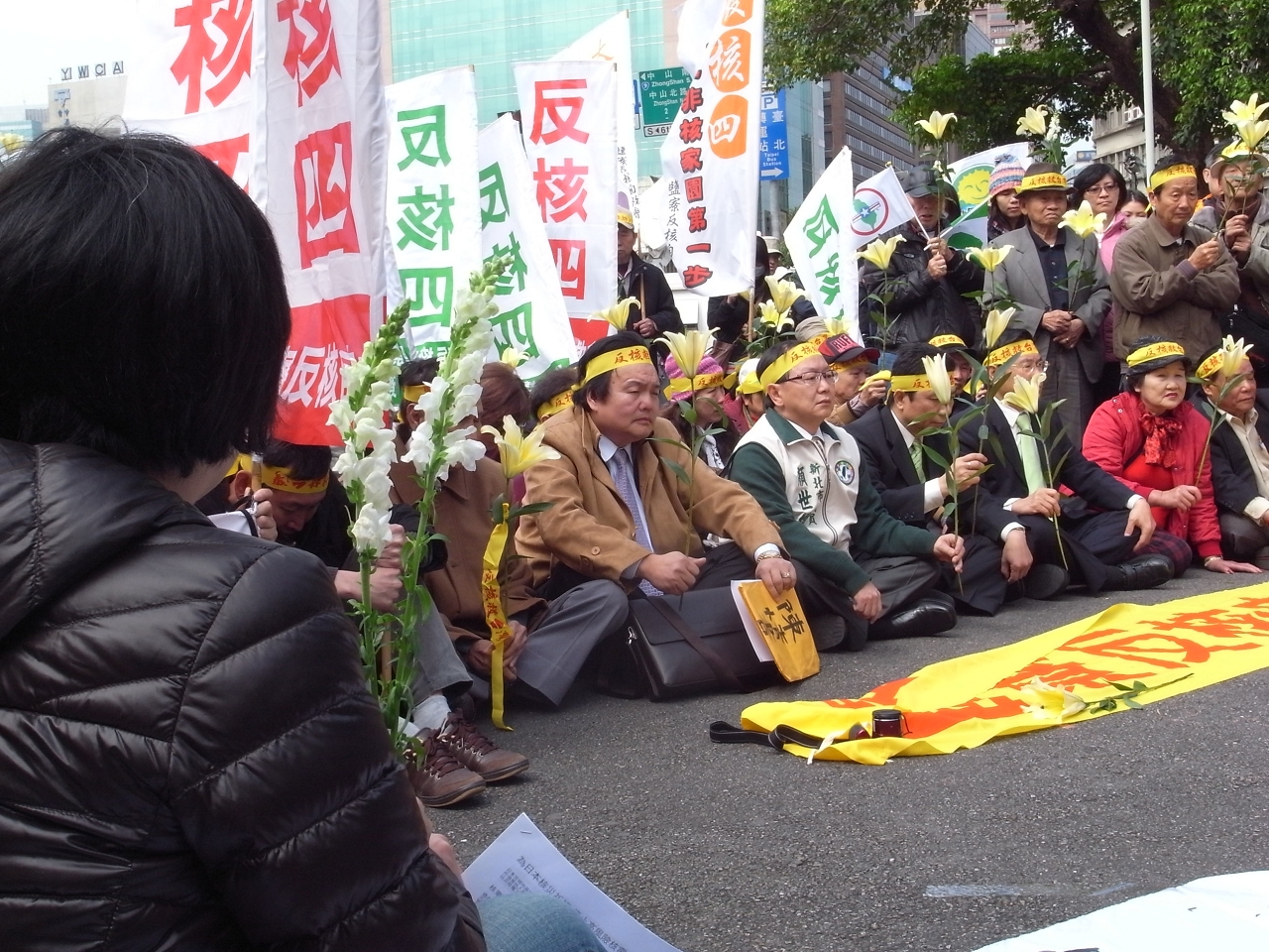 環保團體及貢寮居民人手一支百合花在現場默哀2分鐘,為日本災民祈福。圖片:楊宗興/攝 環保團體及貢寮居民人手一支百合花在現場默哀2分鐘,為日本災民祈福。圖片:楊宗興/攝