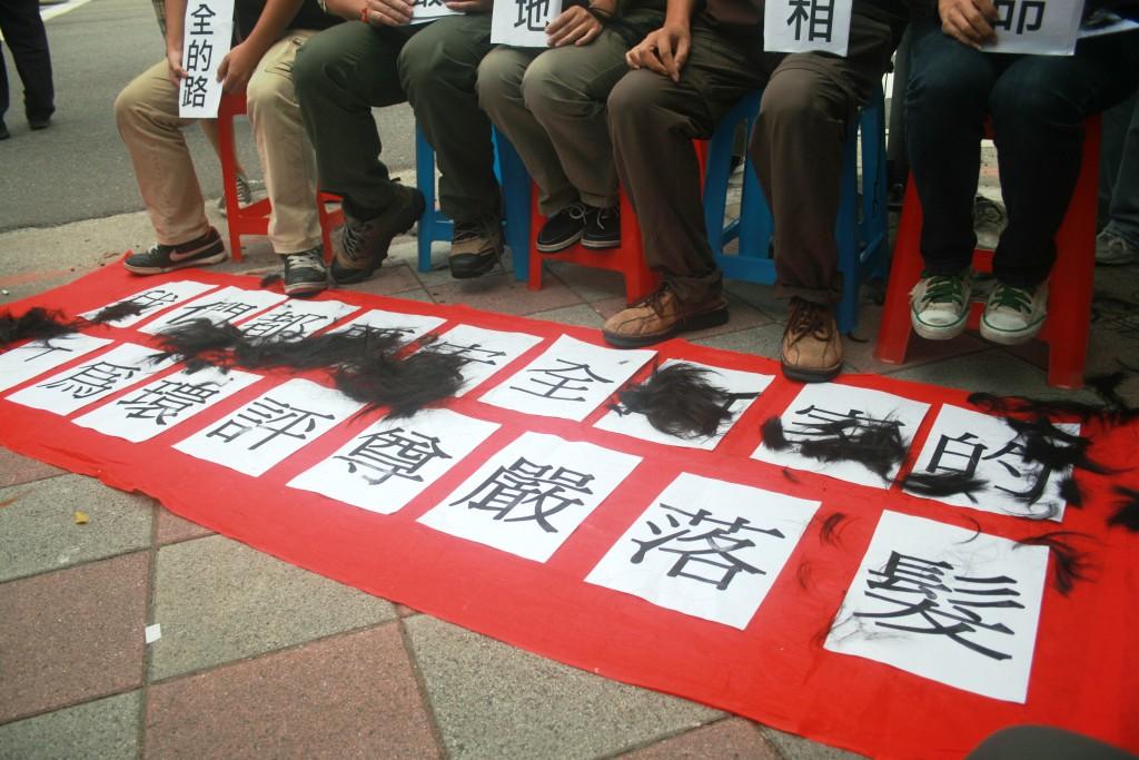 落髮散落在標語上。圖片:李雲深/攝影 落髮散落在標語上。圖片:李雲深/攝影