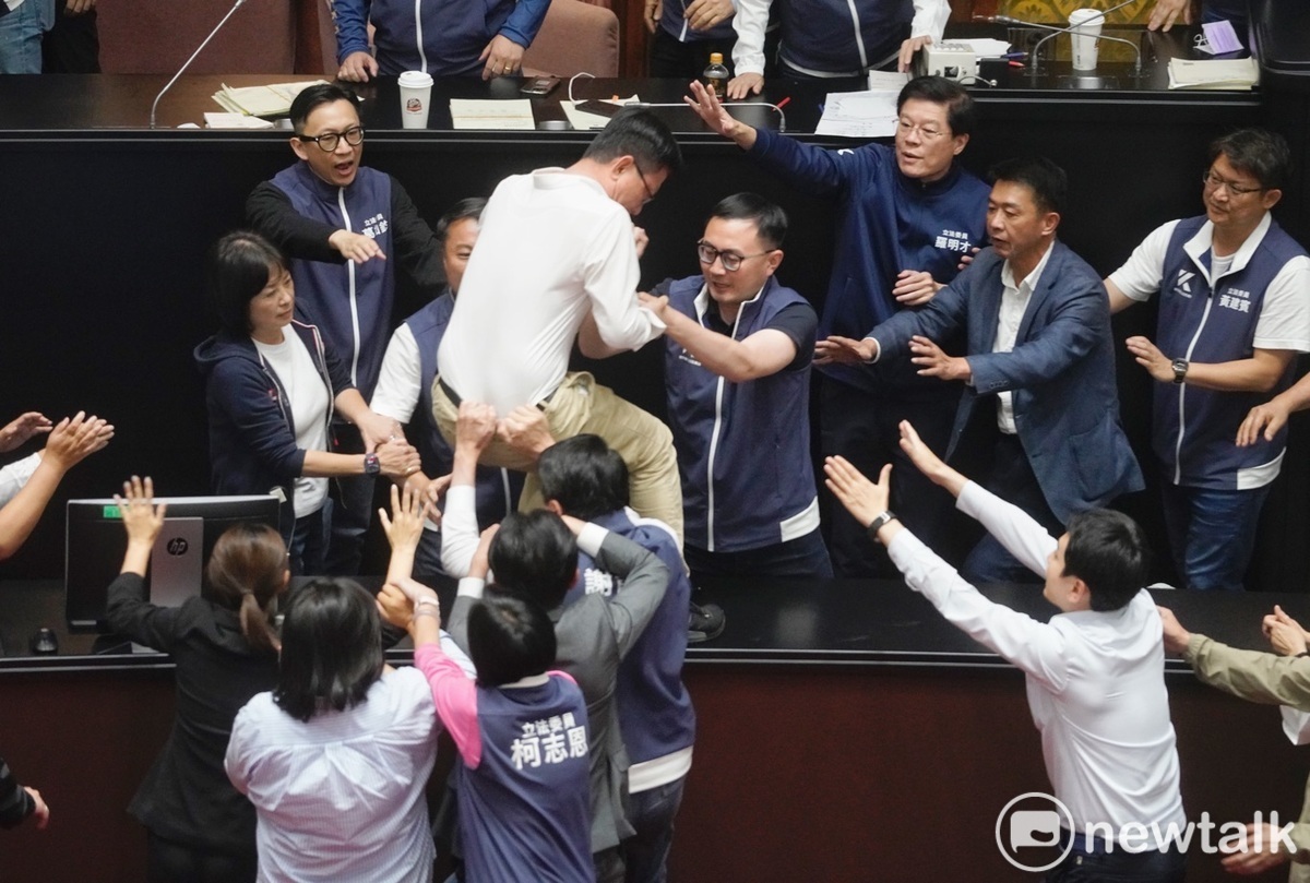  民進黨立委郭國文欲衝上主席台，被國民黨立委謝龍介等人拉住他的褲頭。 圖：張良一/攝（資料照）