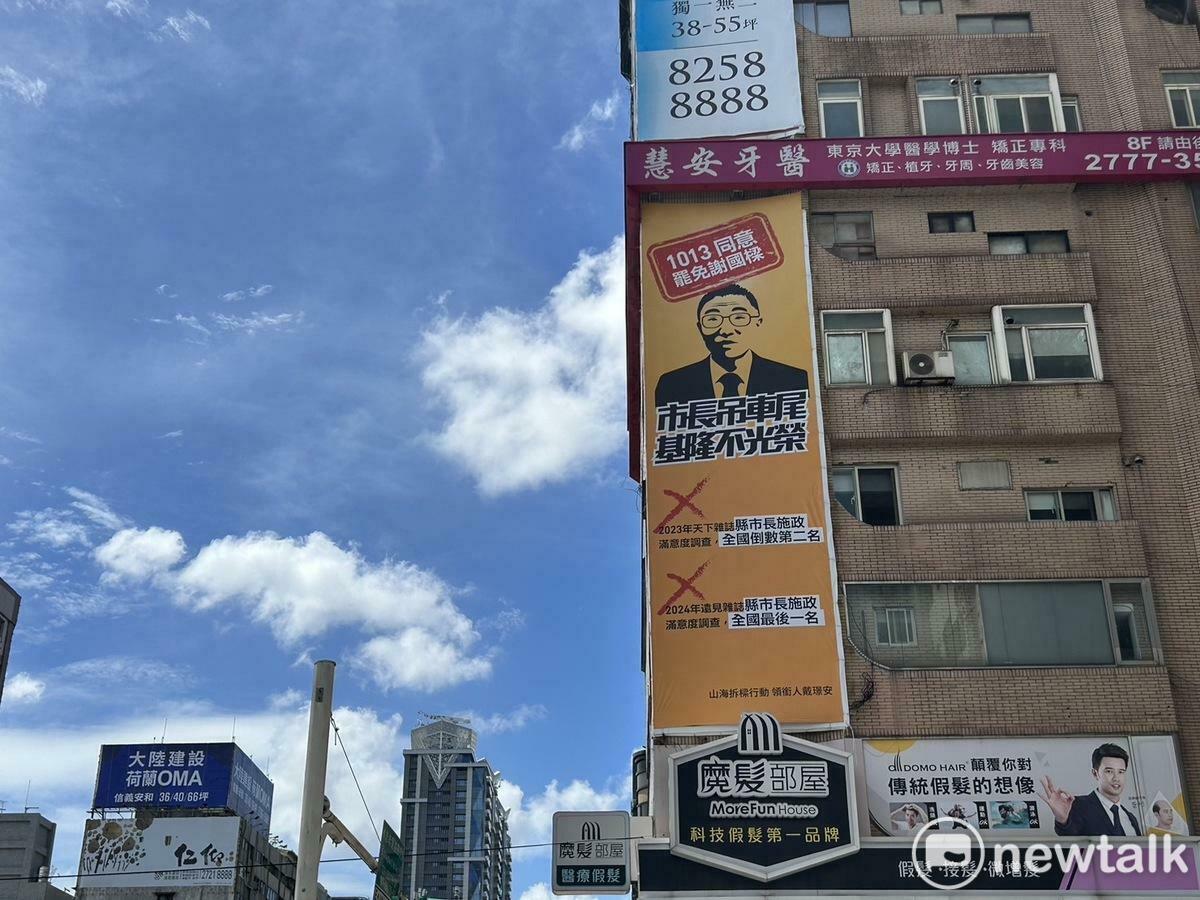  「山海公民拆樑行動」在台北忠孝東路四段一處大樓外牆掛上「謝國樑全台滿意度倒數」的大型看板。 圖：黃宣尹攝 