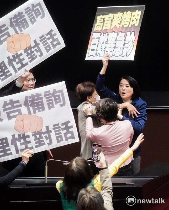 國民黨立院黨團書記長王鴻薇在議場舉牌意圖干擾行政院長卓榮泰的施政報告，而被民進黨立委勸離發言台。   圖：張良一/攝