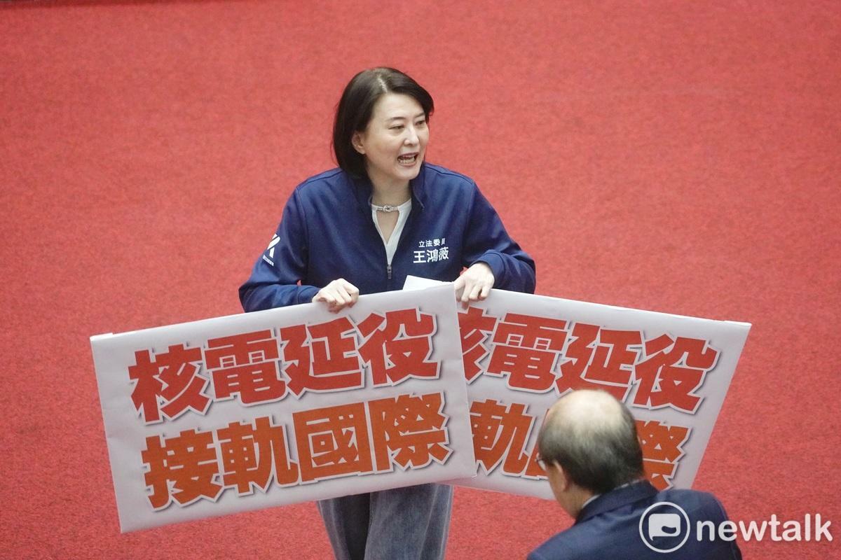 立法院院長韓國瑜在院會敲錘三讀通過核管法第六條文修正草案。圖為國民黨立院黨團書記長王鴻薇在三讀後舉起「核能延役 接軌國際」牌子。   圖：張良一/攝