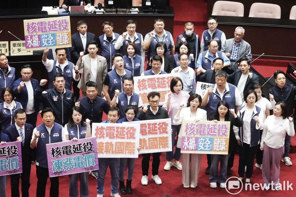 國民黨立委在立法院院長韓國瑜在院會敲鎚三讀通過核管法第六條文修正草案。高舉起「核能延役 接軌國際」牌子喊口號挺核電延役。   圖：張良一/攝