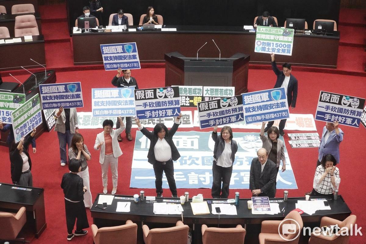 立法院會今（10）天審理軍人待遇條例第五條修正案，民進黨立委在表決前高舉「一手砍國防預算 一手討好軍人」反對此條修正案。   圖：張良一/攝
