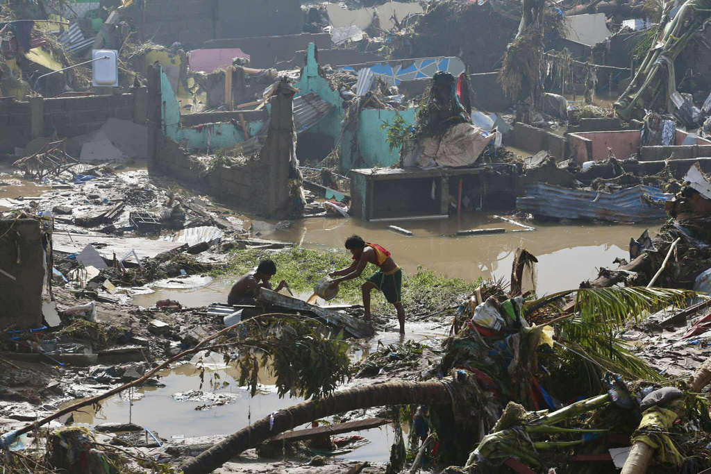  河流暴漲導致多地淹水，汽車、貨櫃與河邊住屋被洪水沖走。 圖：達志影像／美聯社 